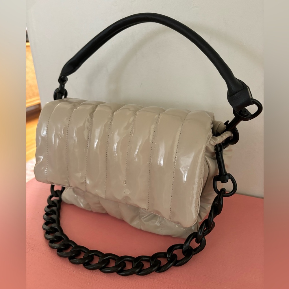 Think Roylan beige bar bag with chain accessory, top handle & crossbody strap.